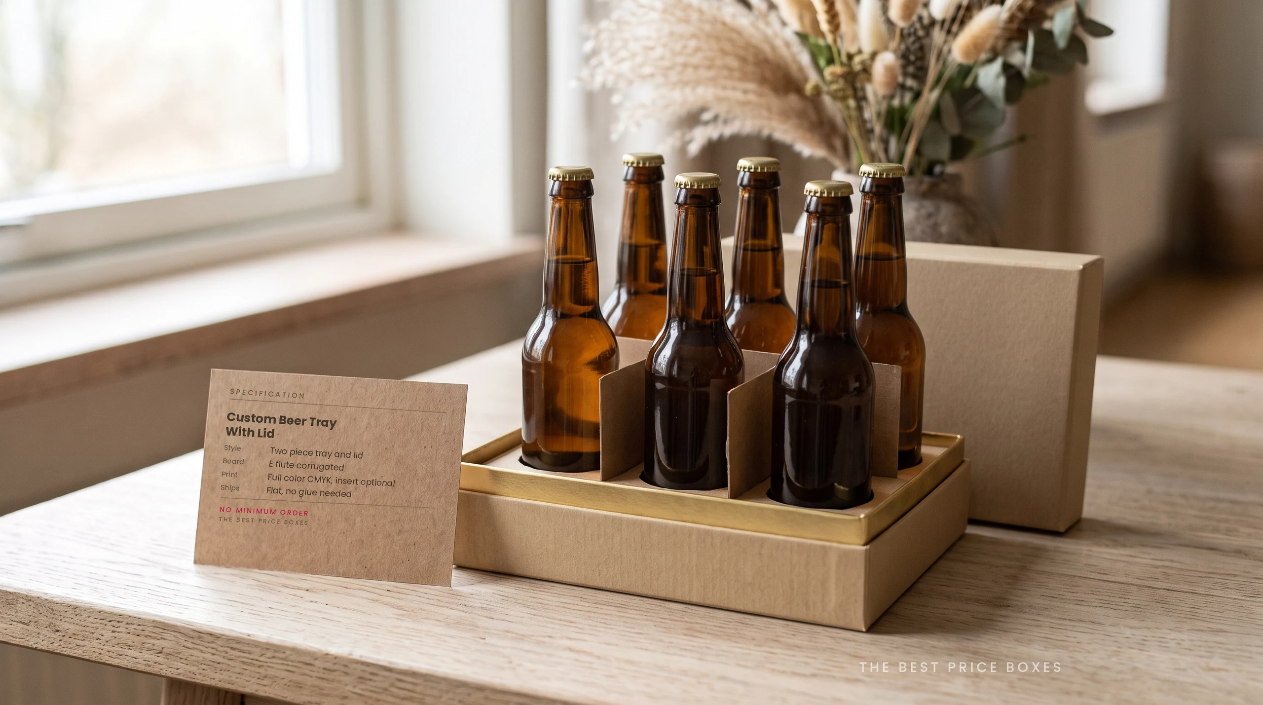 Custom corrugated beer tray in kraft holding six brown bottles in a fitted divider insert, with the flat lid resting behind and a kraft spec card in front.