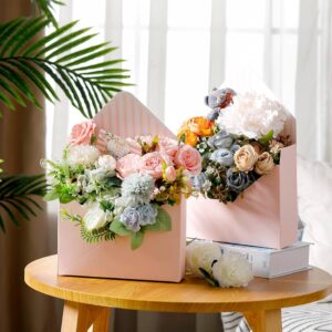 Custom floral box in pink board holding a flower arrangement, styled on a wooden table.