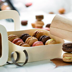 Custom macaron box in kraft with a carry handle, open to show rows of macarons held in the tray.