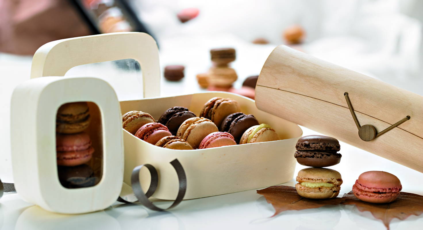 Custom macaron box in kraft with a carry handle, open to show rows of macarons held in the tray.