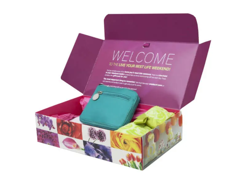 Custom PR box in magenta printed inside and out, opened to show gift items arranged in the tray.