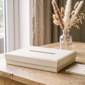 Custom wedding card box in ivory with a gold foil border and a narrow card slot cut into the lid, shown with cream envelopes stacked beside it.